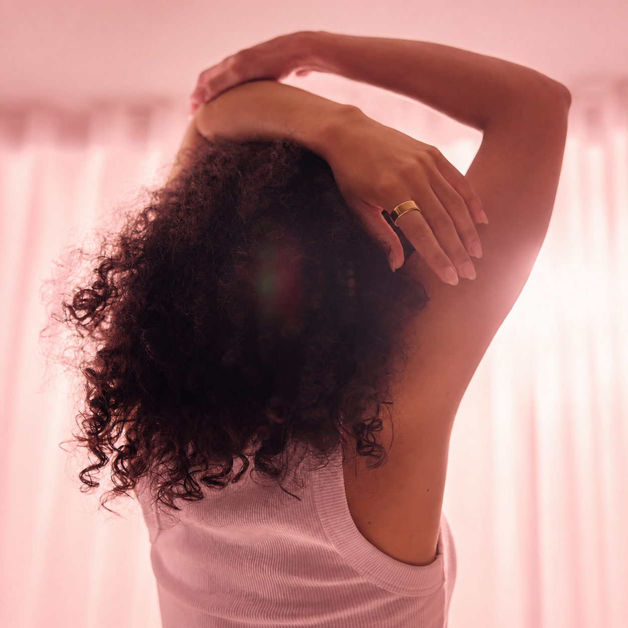 A woman stretching at the start of her day while wearing a gold Auro Ring 5