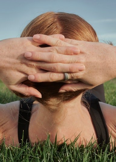 A person relaxing in grass while wearing an Auro Ring 5