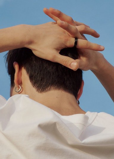 A person resting with their hands behind their head while wearing an Auro Ring 5